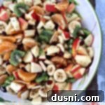 Pinterest image with text "Winter Fruit Salad with Lemon Dressing" alongside a colorful fruit salad.