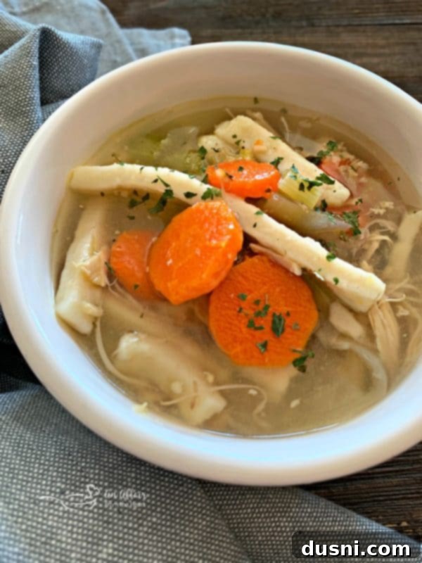 Close-up of a spoon scooping homemade Turkey Noodle Soup, highlighting the rich broth, turkey pieces, and vegetables.