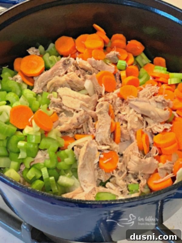 Ingredients for Turkey Noodle Soup laid out: turkey meat, chopped vegetables, and egg noodles.