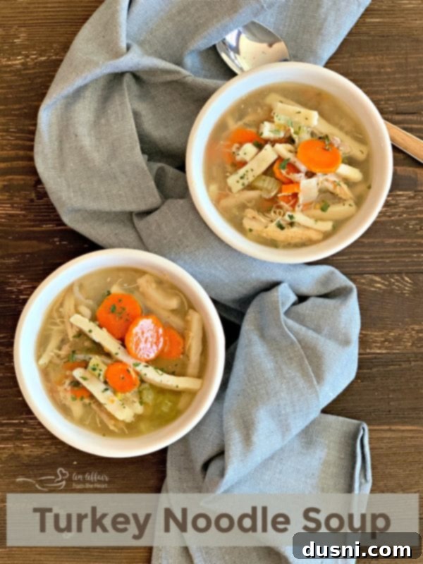A large pot of homemade Turkey Noodle Soup, steaming and ready to be served.
