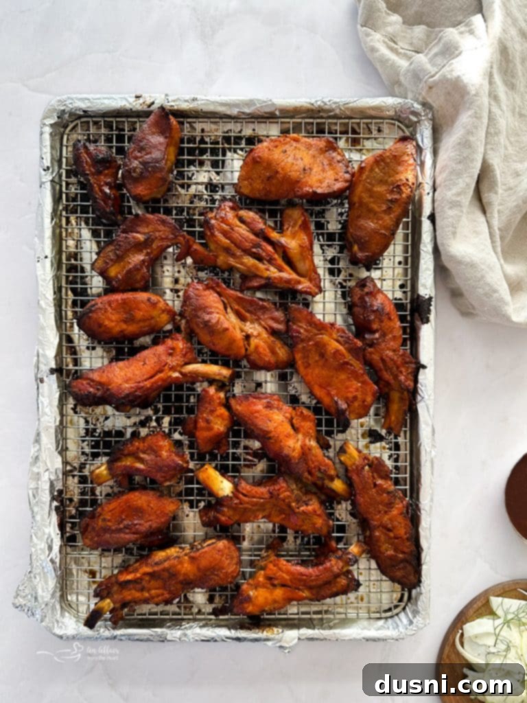Brushing BBQ sauce onto the slow-cooked ribs