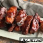Close up of Slow Cooker Dr. Pepper BBQ Ribs on a white serving plate