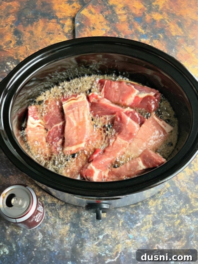 Pouring Dr. Pepper over pork ribs in the slow cooker