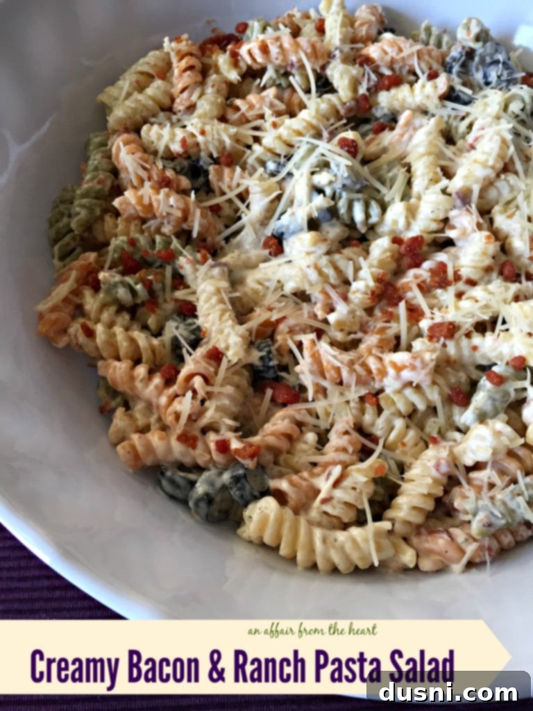 Creamy Ranch Pasta Salad with Bacon 2 Delicious Creamy Bacon & Ranch Pasta Salad in a white bowl, garnished with herbs