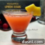 martini in a martini glass with a slice of pineapple for garnish. text "pineapple upside down cake martini"