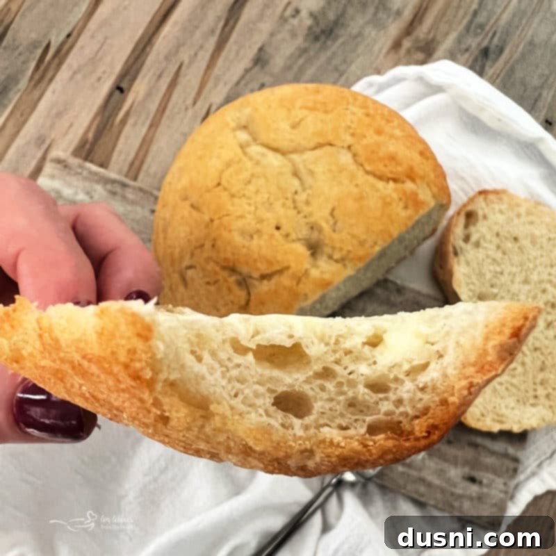 Easy Peasant Bread A close-up of a thick slice of freshly baked peasant bread, highlighting its airy crumb and slightly chewy texture.
