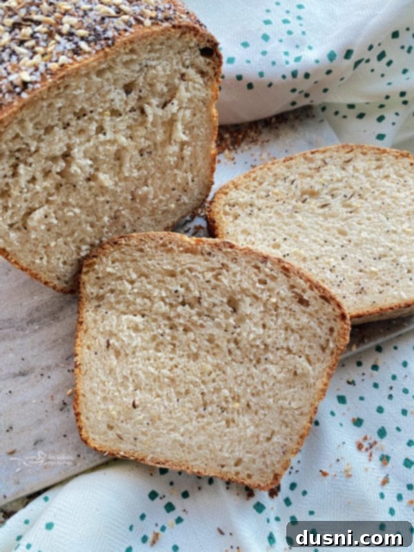 Rustic Farmhouse Loaf 6 Sliced loaf of Everything Sauerkraut Bread on a cutting board, showing its unique texture and ingredients.