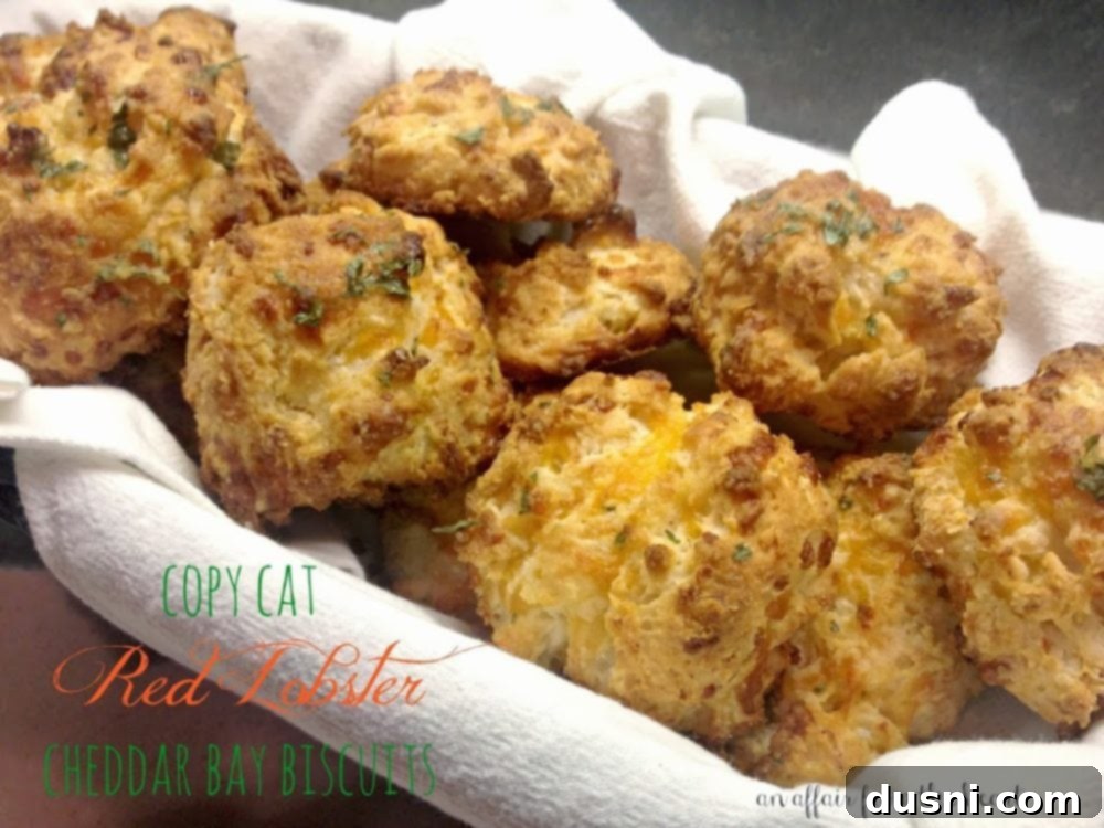 Biscuits in a white cloth lined basket with text "copy cat red lobster cheddar bay biscuits"