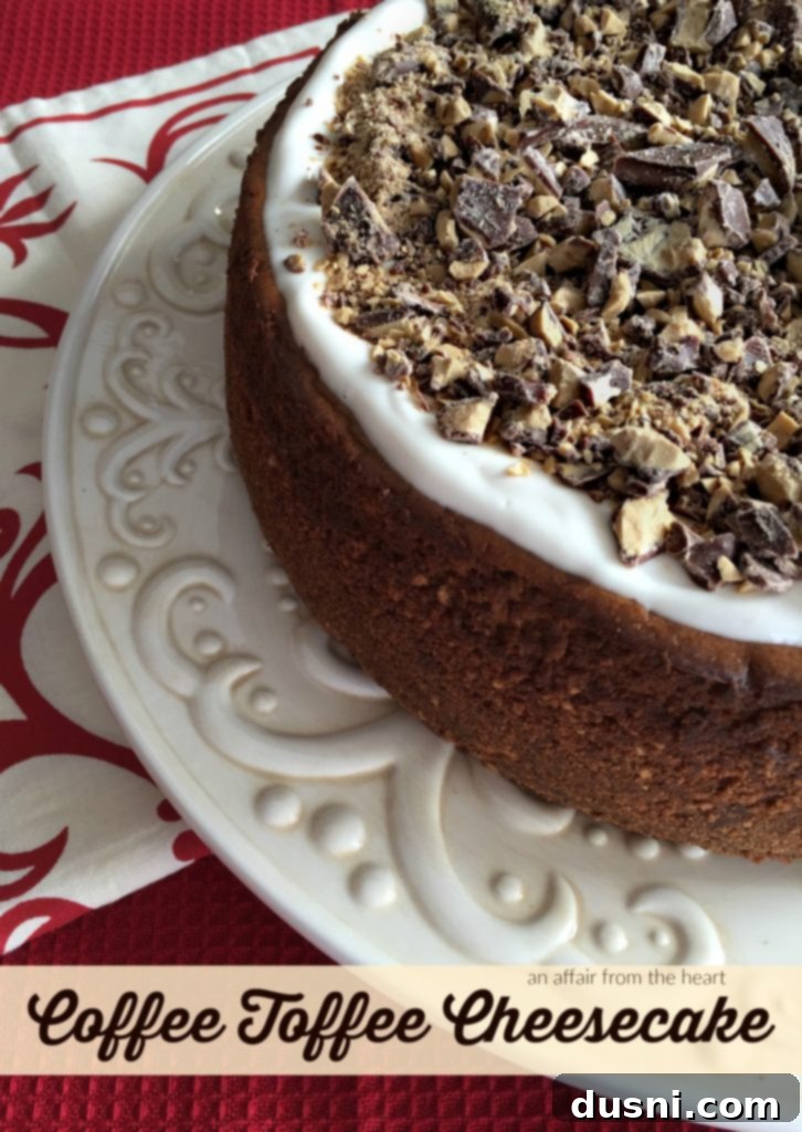 Delicious slice of Coffee Toffee Cheesecake on a white plate, garnished with toffee bits