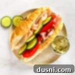 Garden Club Hoagie Sandwich and pickles on a tan plate.