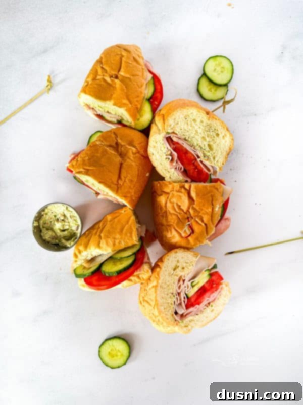 Garden Club Hoagie Sandwich, cut in half, showcasing layers of turkey, ham, veggies, and spread.