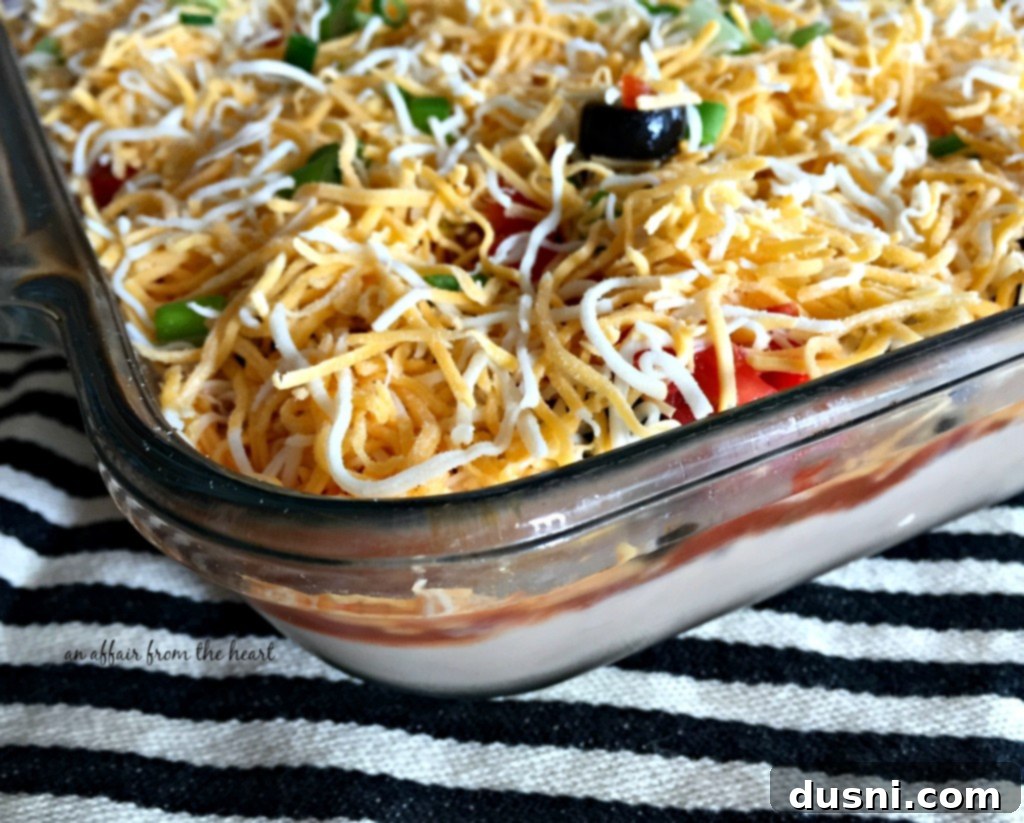 Variety of chips and fresh vegetables for dipping into Mexican Layered Bean Dip