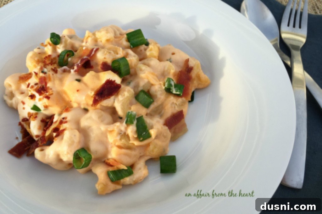 A close-up of a generous serving of loaded mac 'n cheese, showcasing its creamy texture and abundant toppings