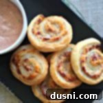 Reuben Pinwheels with thousand island dressing on a black serving plate