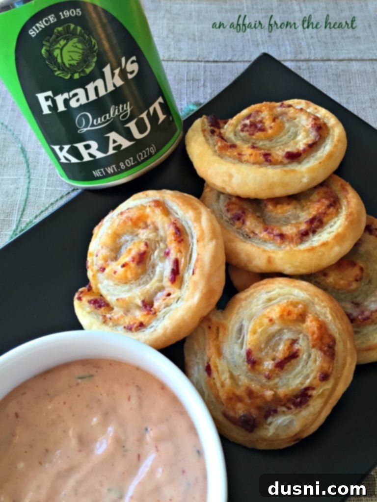A large platter of golden brown Reuben Pinwheels, garnished and ready for a party