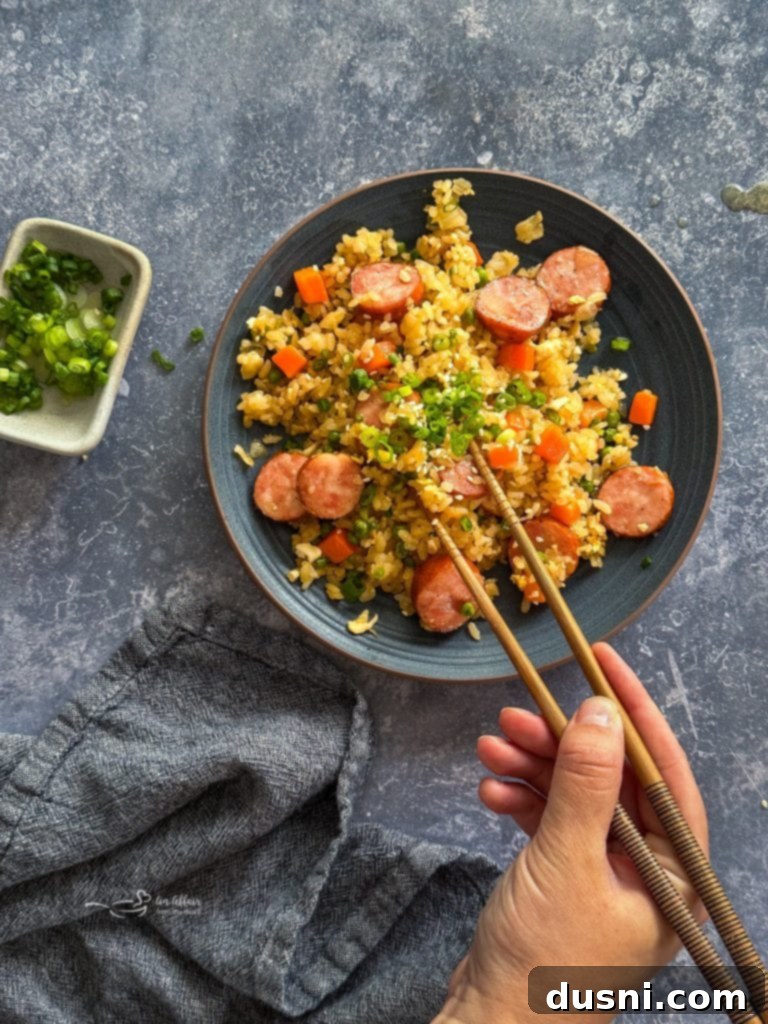Hearty Kielbasa Fried Rice 10 A single serving of Kielbasa Fried Rice in a bowl, with a fork, ready to eat