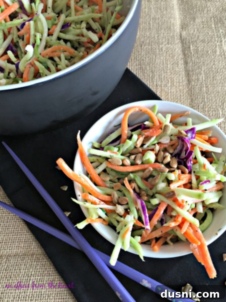 Vibrant Broccoli Slaw with julienned carrots and sunflower seeds in a white bowl