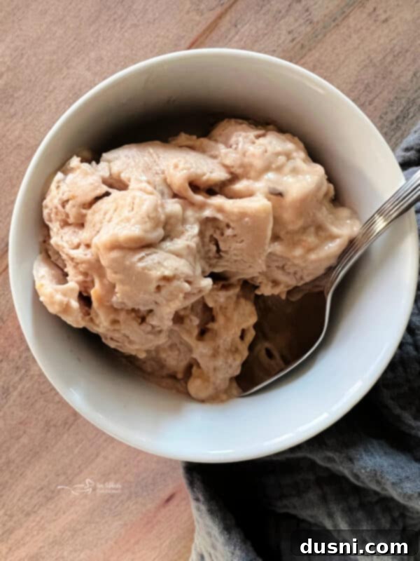 A bowl of creamy peanut butter banana ice cream with a spoon.