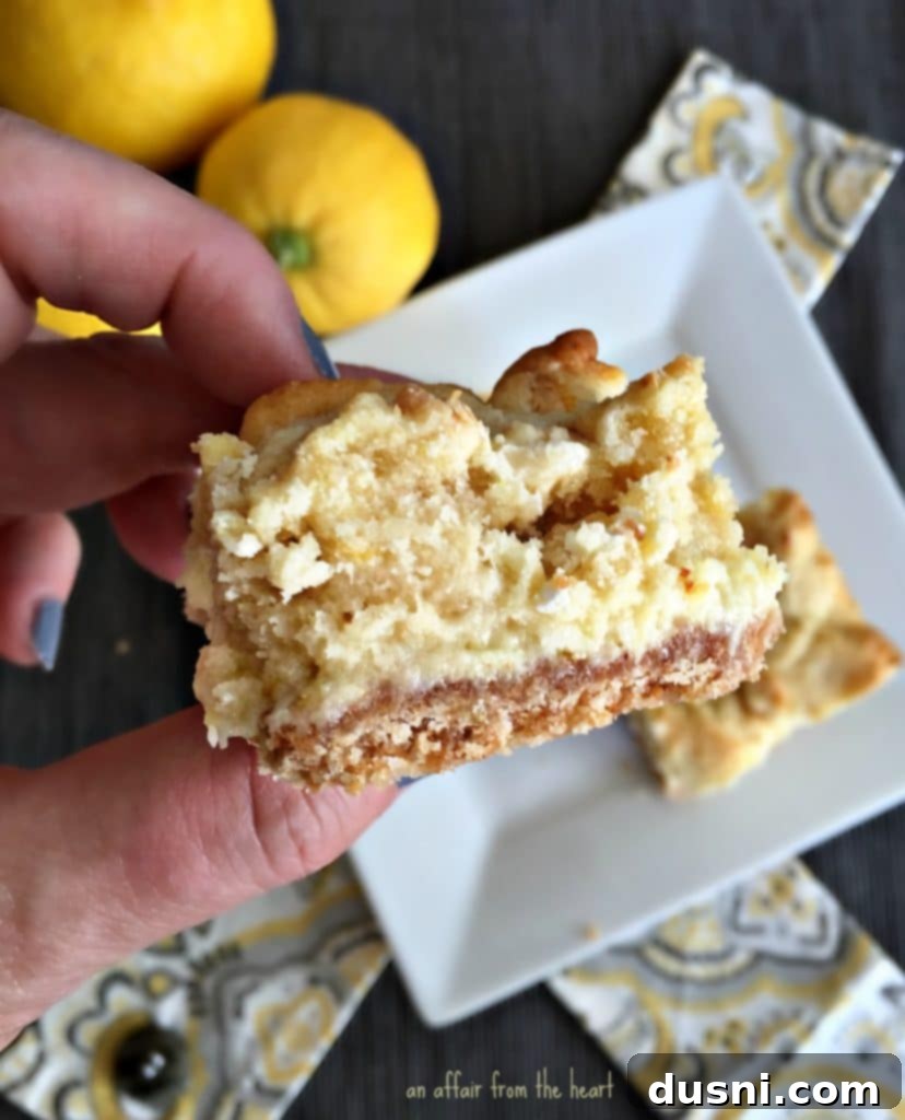 Zesty Lemon Cheesecake Bars 4 Stack of Lemon Cheesecake Bars on a white plate, highlighting the golden brown cookie top.
