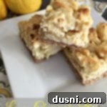 Zesty Lemon Cheesecake Bars 6 Bars stacked on a white plate with text "Lemon Cheesecake Bars"