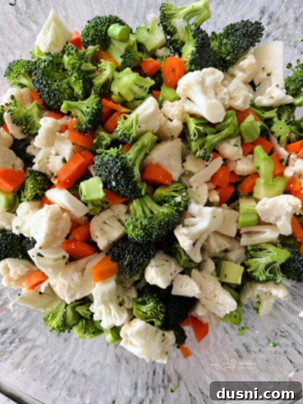 Vibrant Italian Garden Salad 6 Freshly chopped cauliflower, broccoli, and carrots in a large mixing bowl.