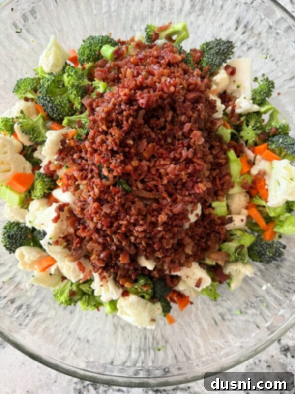 Vibrant Italian Garden Salad 7 Crumbled bacon being added to the chopped vegetables in a bowl.