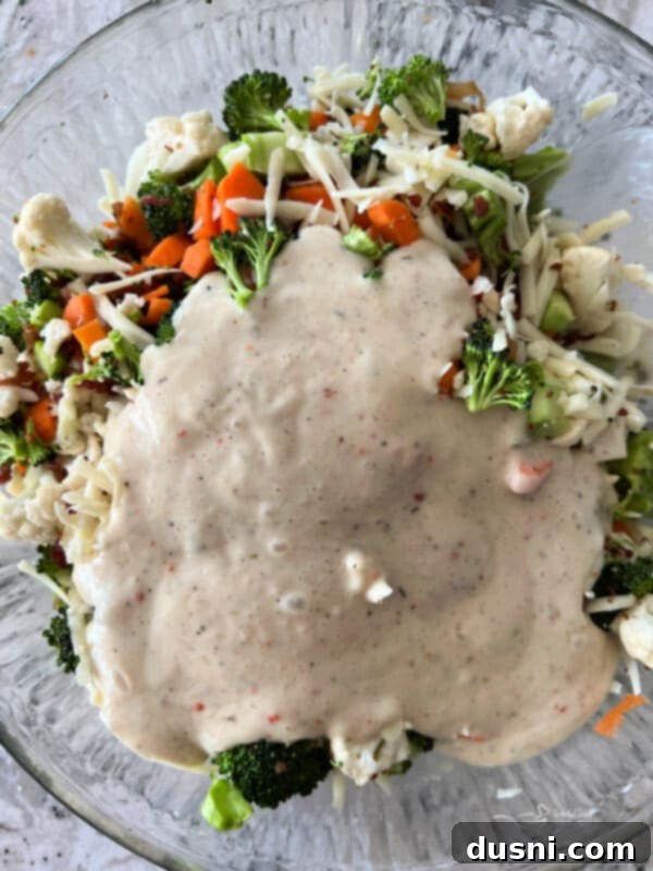 Vibrant Italian Garden Salad 10 Creamy Italian dressing being poured over the salad ingredients.