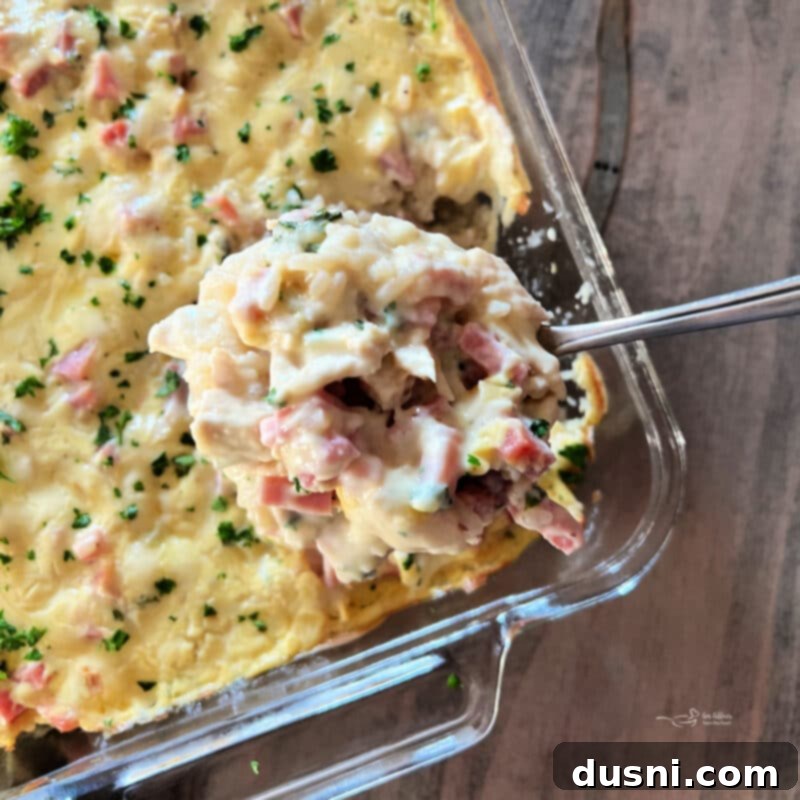 Close-up of the Chicken Cordon Bleu Casserole with Rice, showing layers of chicken, ham, rice, and creamy sauce before baking