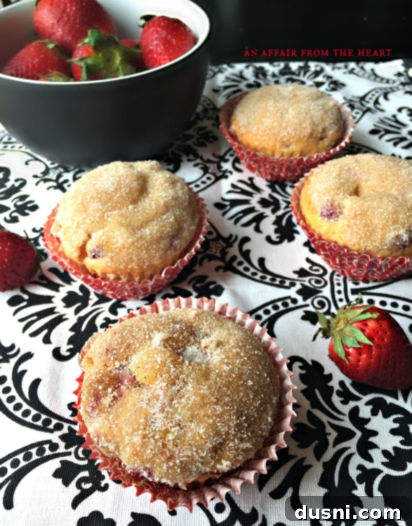 Irresistible Strawberry Cheesecake Muffins 7 Strawberry Cheesecake Muffins being dusted with cinnamon sugar before baking.