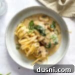 Creamy Chicken and Mushroom Florentine Pasta 23 Close up of Chicken Mushroom Florentine pasta on a white plate.