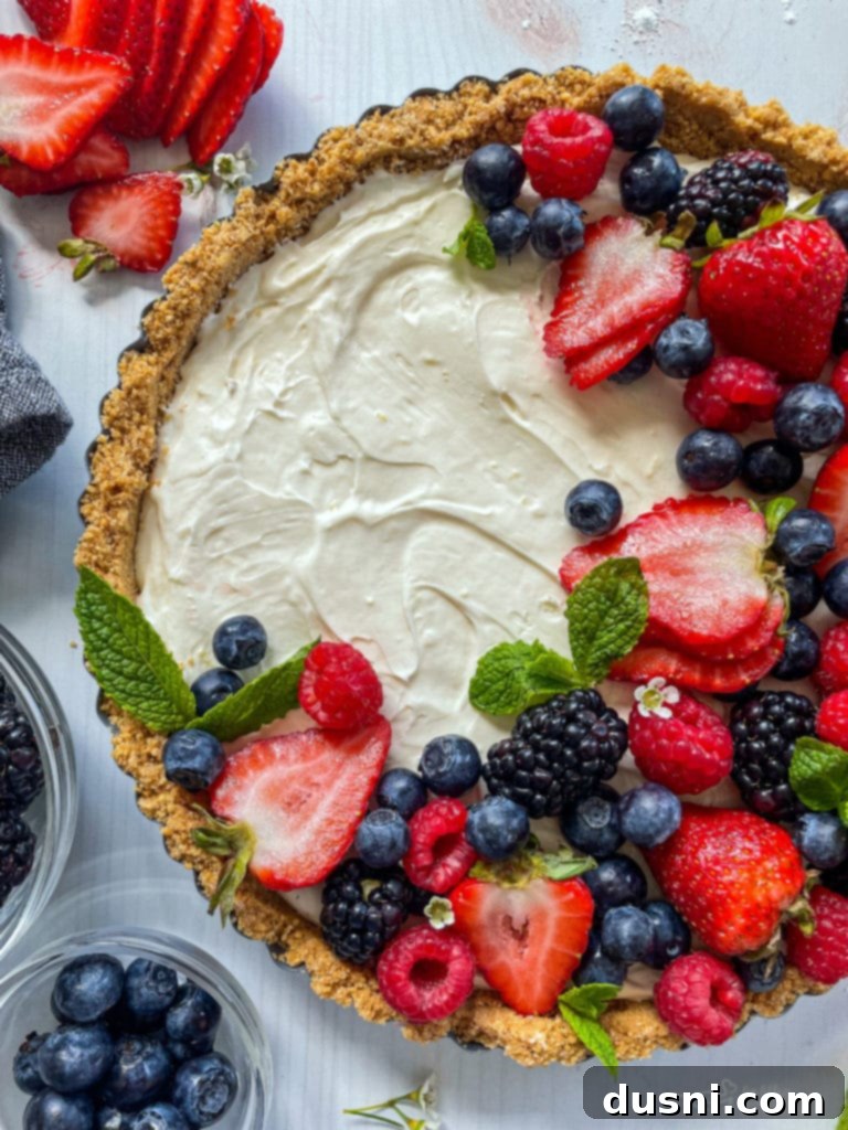 Top view of no bake fruit tart with fresh blueberries, strawberries, blackberries, and raspberries