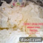 Whipped Coconut Cheesecake Frosting 2 Frosting in a bowl with text "coconut cream cheese whipped cream frosting"