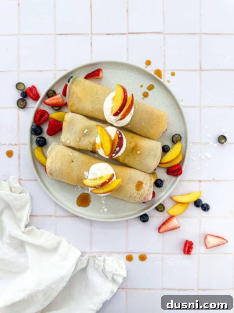 Golden Crepes Topped with Summer Fruits 4 Sweet Crepes with Summer Fruits presented on a plate