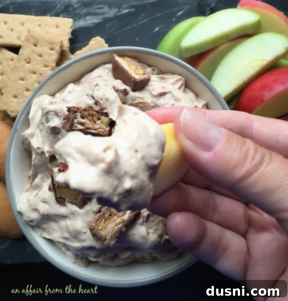 Decadent Snickers Dip 11 Snickers Dip served with fresh apple slices, highlighting healthy pairing.