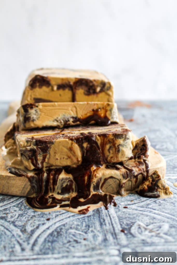 Close-up of a slice of ice cream cake, showing the rich coffee ice cream and donut layers.