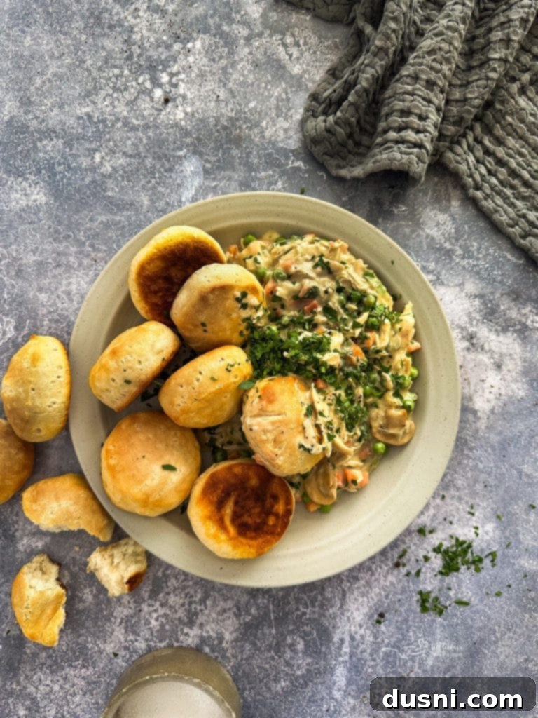 A close-up of Chicken à la King in a skillet, showcasing its creamy texture with peas and carrots.