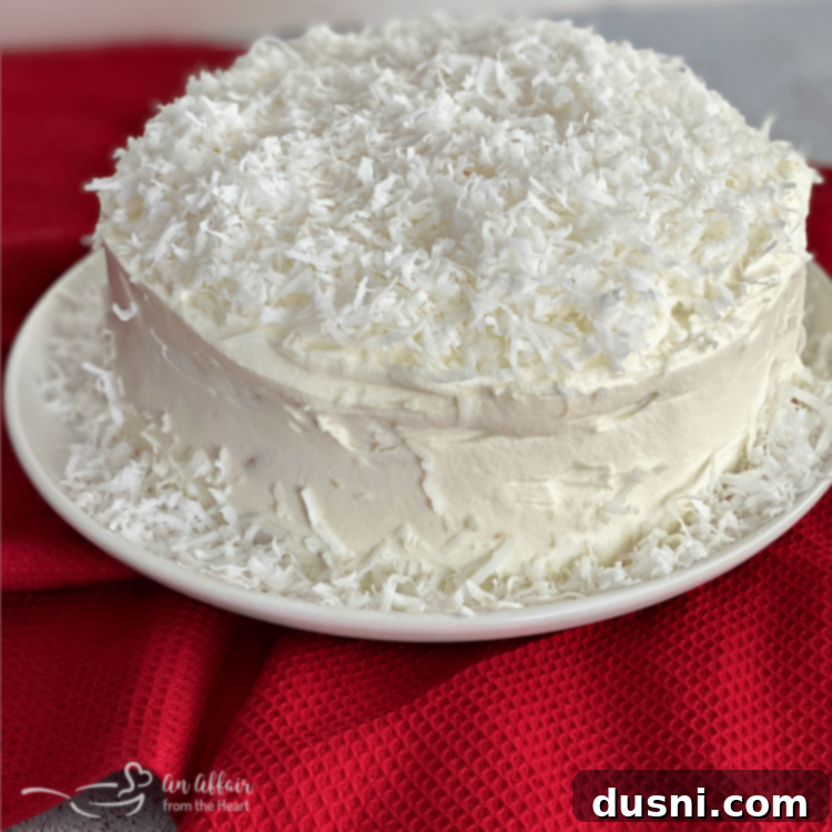 A whole Coconut Cream Poke Cake with Coconut Whipped Cream Frosting, ready to be served.