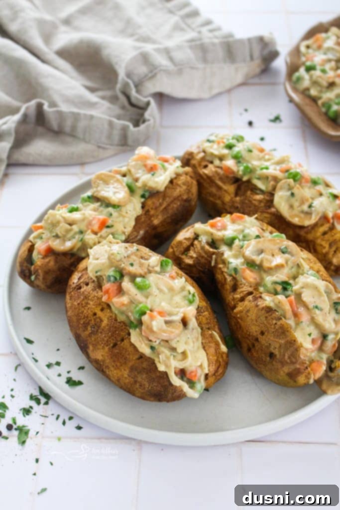 Two generously stuffed Wendy's style Chicken à la King Baked Potatoes on a plate
