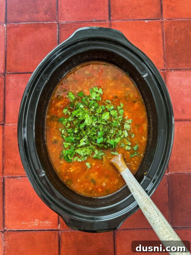 Adding fresh cilantro to the finished soup