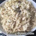 Close up of orzo in a white bowl with text "creamy Mushroom Orzo"