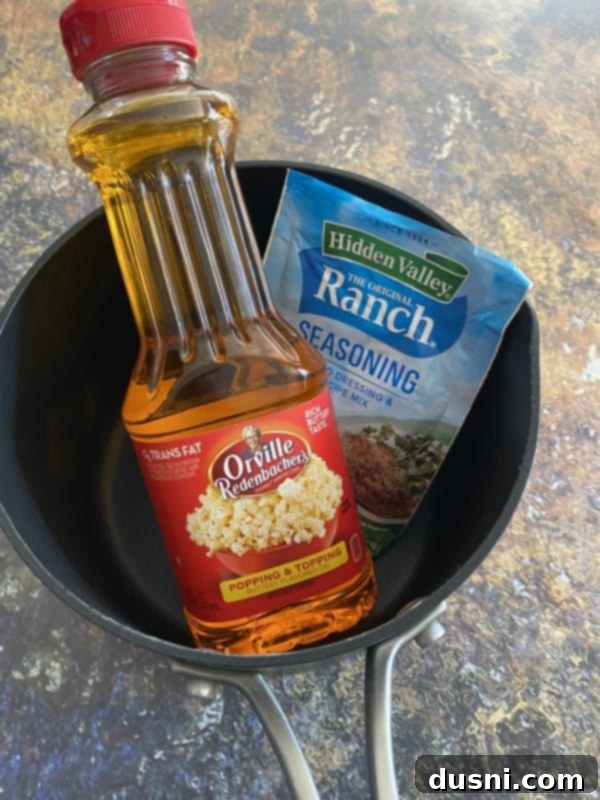 Ingredients for Touchdown Snack Mix laid out: popcorn oil, ranch seasoning, various crackers, peanuts, Bugles, and potato chips.