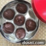 overhead of Peanut Butter Chocolate Chip Cookie Dough Truffles in a candy tin
