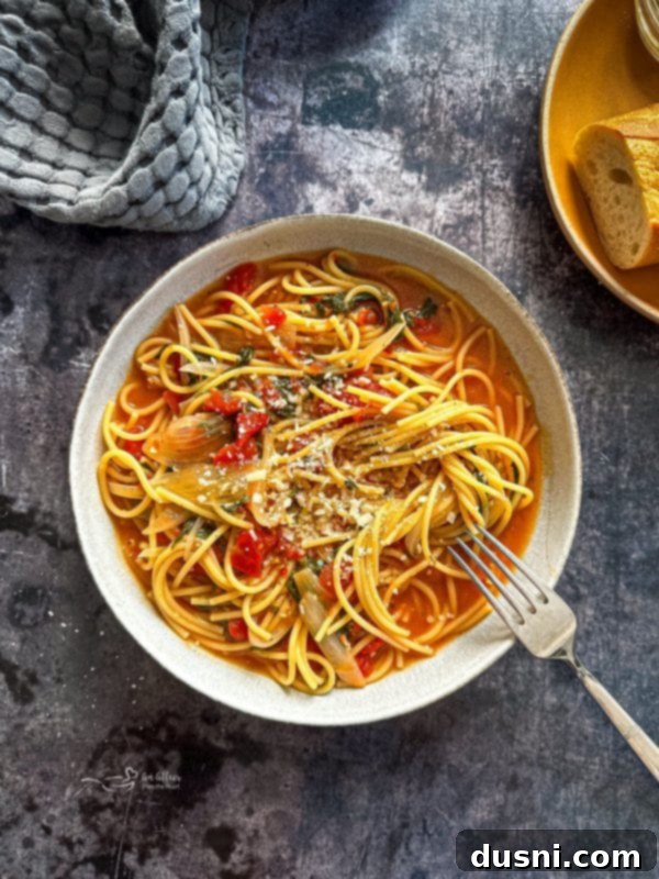All the raw ingredients for Italian Wonderpot laid out on a cutting board, including pasta, spinach, tomatoes, and spices.