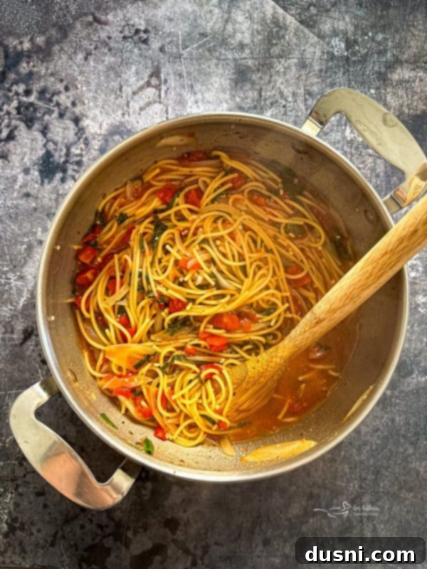 A close-up of the Italian Wonderpot Pasta boiling on the stove with the lid slightly ajar.