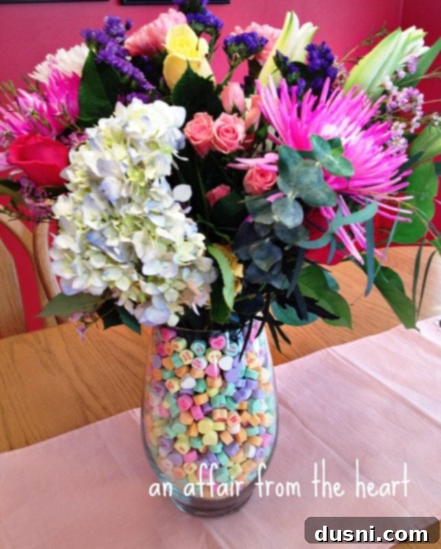 A charming Valentine's Day centerpiece featuring conversation heart candies arranged around a white candle, creating a romantic atmosphere.