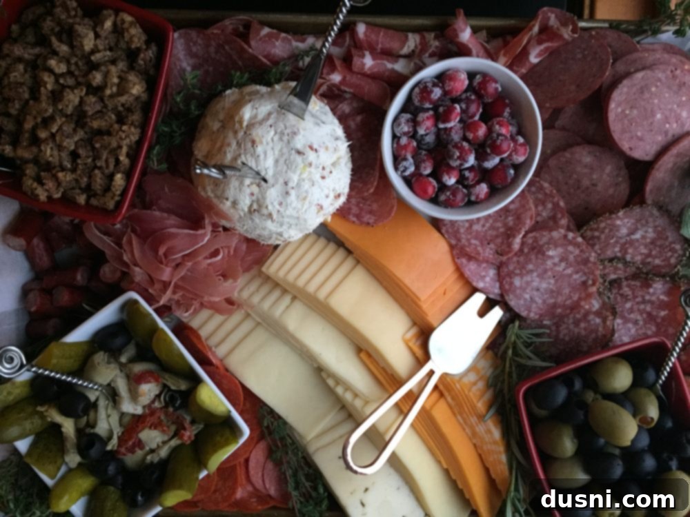 Candied Pecans 6 An assembled charcuterie board featuring various cheeses, meats, fruits, and a small bowl of sugared pecans.