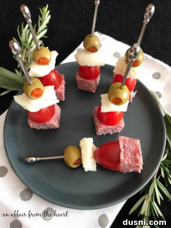 The Ultimate Summer Sausage Cheese Ball 11 Close-up of a Summer Sausage Skewer featuring a grape tomato, cheese, and olive.