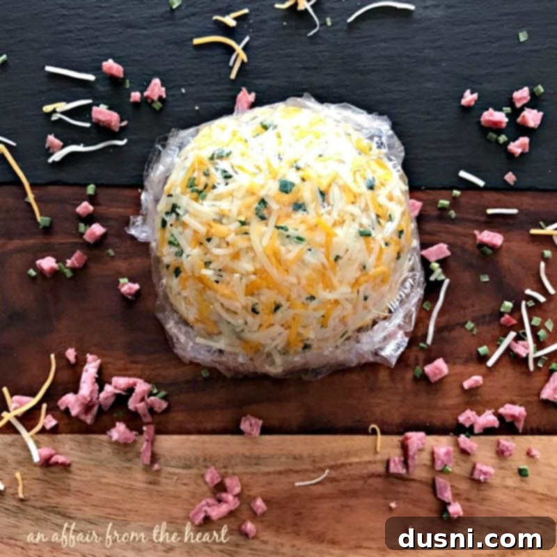 The Ultimate Summer Sausage Cheese Ball 15 Mixing bowl with cream cheese, chopped summer sausage, and green onions for the cheese ball.