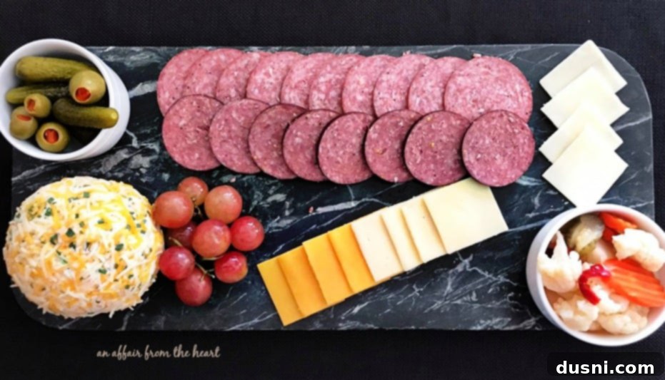 The Ultimate Summer Sausage Cheese Ball 6 A diverse charcuterie spread with Johnsonville Summer Sausage, various cheeses, and fruit.