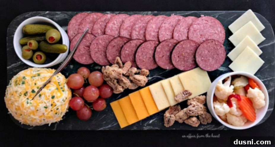 The Ultimate Summer Sausage Cheese Ball 7 Close-up view of a charcuterie board featuring Summer Sausage, a variety of cheeses, and sweet elements.